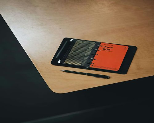 A neat desk with a notebook and pen