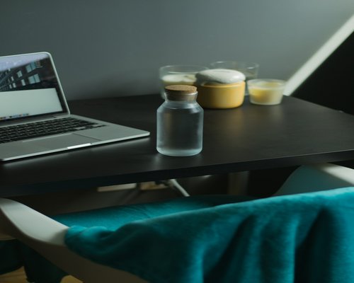 Glass of water next to a laptop on a desk